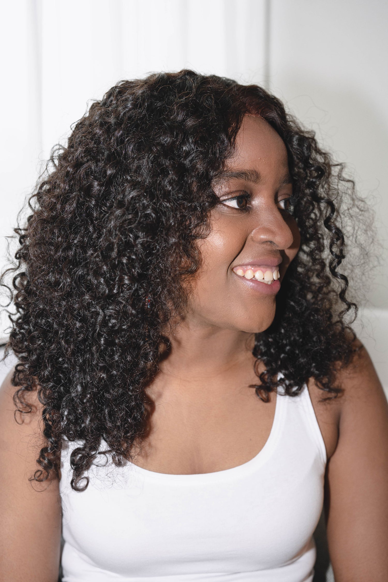 Adora wig featuring vibrant, kinky curly texture made from 100% human hair, offering a voluminous and natural look with bouncy curls. Available in a variety of shades for a personalized style.