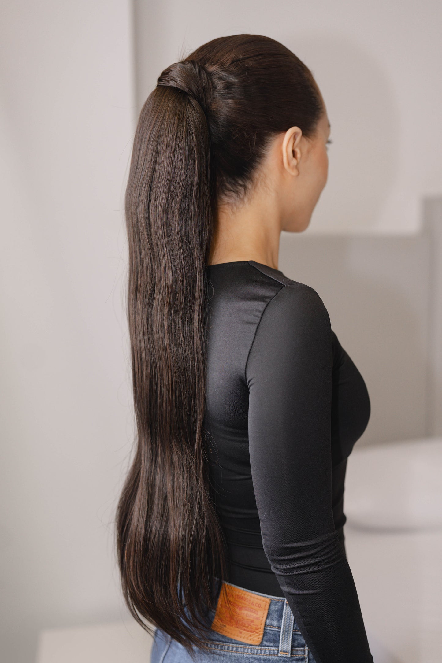 22-inch Bone Straight ponytail made of 100% raw human hair in natural black (Color 1B), sleek and silky texture, 100g.